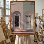 Load image into Gallery viewer, Plakat med farverige døre | Sommer og Strand Plakater | Denne plakat viser en pink og en blå dør side om side, hver i en buet dørkarm, på en farverig bygning. Perfekt til dem, der elsker unik arkitektur.
