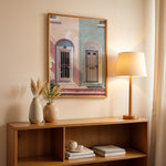 Load image into Gallery viewer, Plakat med farverige døre | Sommer og Strand Plakater | Denne plakat viser en pink og en blå dør side om side, hver i en buet dørkarm, på en farverig bygning. Perfekt til dem, der elsker unik arkitektur.
