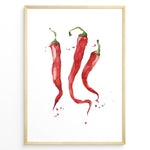 Load image into Gallery viewer, Watercolor plakat illustration of three red chili peppers with green stems and paint splatters, framed in black, ideal for modern kitchen or dining room décor.
