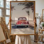Load image into Gallery viewer, Plakat med vintage bil | Sommer og Strand Plakater | Denne plakat viser en vintage rød bil parkeret ved en strandvej med havet og palmetræer i baggrunden. Perfekt til dem, der elsker retro og strandstemning.

