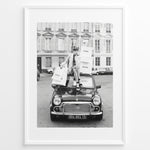 Load image into Gallery viewer, Fashion Plakat | Chanel Shopping Woman Plakaty.dk | Fashion plakat shopping i Paris | Kvinde i blazer og hæle sidder på bil med Chanel-poser foran klassisk bygning. Sort-hvid modefoto.
