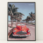 Load image into Gallery viewer, Plakat med vintage rød bil | Sommer og Strand Plakater | Denne plakat viser en klassisk rød cabriolet parkeret på en gade med palmer ved stranden. Perfekt til retro- og strandelskere.
