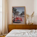 Load image into Gallery viewer, Plakat med vintage rød bil | Sommer og Strand Plakater | Denne plakat viser en klassisk rød cabriolet parkeret på en gade med palmer ved stranden. Perfekt til retro- og strandelskere.
