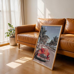 Load image into Gallery viewer, Plakat med vintage rød bil | Sommer og Strand Plakater | Denne plakat viser en klassisk rød cabriolet parkeret på en gade med palmer ved stranden. Perfekt til retro- og strandelskere.
