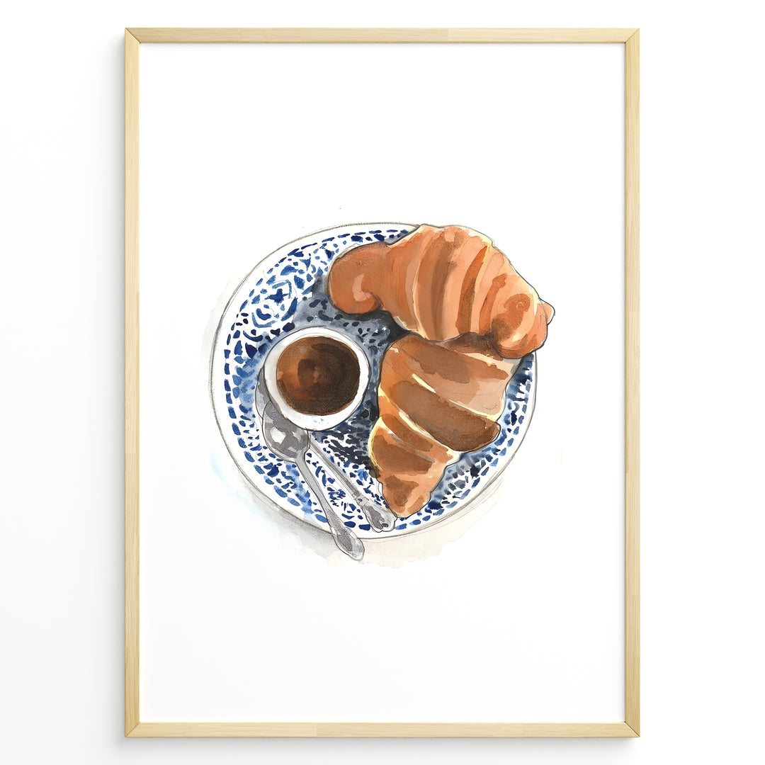 Watercolor wall art of a croissant and espresso cup on a blue decorative plate, ideal for French café, kitchen, or breakfast nook wall décor.