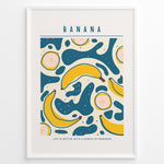 Load image into Gallery viewer, Colorful banana art print plakat with abstract teal and yellow shapes, text reading “Life is better with a bunch of bananas,” framed in white.
