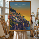 Load image into Gallery viewer, Amalfi Coast Vintage Travel Plakat | Vintage Travel Poster | Denne plakat viser en farverig illustration af Amalfi kysten i Italien, med pastelfarvede bygninger stablet på en stejl skråning mod havet. Perfekt til rejse- og kunstelskere.
