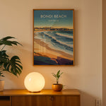 Load image into Gallery viewer, Bondi Beach Vintage Travel Plakat | Vintage Travel Poster | Denne plakat viser en farverig illustration af Bondi Beach i Australien, med bølger, der slår ind mod kysten og en by i baggrunden. Perfekt til dem, der elsker strand- og byliv.
