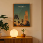 Load image into Gallery viewer, Marrakech Vintage Travel Plakat | Vintage Travel Poster | Denne plakat viser en stiliseret illustration af Marrakech med en høj minaret og palmetræer mod en gradienthimmel.
