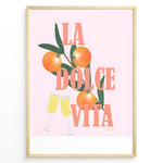 Load image into Gallery viewer, Stylish La Dolce Vita poster with oranges, green leaves, and champagne glasses on a pink background, framed as Italian-inspired wall art.
