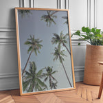 Load image into Gallery viewer, Plakat med palmer | Sommer og Strand Plakater | Denne plakat viser høje palmer set nedefra mod en gradient af lyseblå og mørkere himmel. Perfekt til dem, der elsker tropiske omgivelser.
