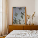 Load image into Gallery viewer, Plakat med palmer | Sommer og Strand Plakater | Denne plakat viser høje palmer set nedefra mod en gradient af lyseblå og mørkere himmel. Perfekt til dem, der elsker tropiske omgivelser.

