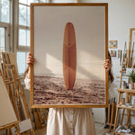 Load image into Gallery viewer, Plakat med surfbræt på stranden | Sommer og Strand Plakater | Denne plakat viser et surfbræt stående oprejst på en rolig sandstrand med havet i baggrunden. Perfekt til strand- og surfentusiaster.
