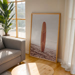 Load image into Gallery viewer, Plakat med surfbræt på stranden | Sommer og Strand Plakater | Denne plakat viser et surfbræt stående oprejst på en rolig sandstrand med havet i baggrunden. Perfekt til strand- og surfentusiaster.
