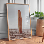 Load image into Gallery viewer, Plakat med surfbræt på stranden | Sommer og Strand Plakater | Denne plakat viser et surfbræt stående oprejst på en rolig sandstrand med havet i baggrunden. Perfekt til strand- og surfentusiaster.
