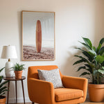 Load image into Gallery viewer, Plakat med surfbræt på stranden | Sommer og Strand Plakater | Denne plakat viser et surfbræt stående oprejst på en rolig sandstrand med havet i baggrunden. Perfekt til strand- og surfentusiaster.
