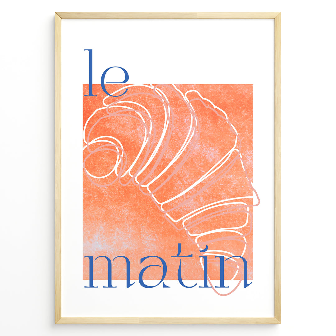 Le Matin poster with minimalist croissant illustration in orange and blue text on a white background in a golden frame.