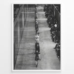 Load image into Gallery viewer, Fashion Plakat | Black &amp; White Fashion Runway – Editorial Wall Art Print Plakaty.dk | Black and white photograph of runway models walking in a single-file line during a fashion show, with seated spectators on one side of the runway.
