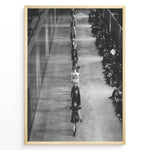Load image into Gallery viewer, Fashion Plakat | Black &amp; White Fashion Runway – Editorial Wall Art Print Plakaty.dk | Black and white photograph of runway models walking in a single-file line during a fashion show, with seated spectators on one side of the runway.
