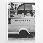 Load image into Gallery viewer, Fashion Plakat | Burberry Vintage Van &amp; Storefront – Black &amp; White Fashion Poster Plakaty.dk | Black and white photo of a vintage Burberry van parked in front of a Burberry Brit boutique, combining retro automotive style with a luxury storefront backdrop.
