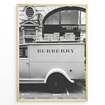 Load image into Gallery viewer, Fashion Plakat | Burberry Vintage Van &amp; Storefront – Black &amp; White Fashion Poster Plakaty.dk | Black and white photo of a vintage Burberry van parked in front of a Burberry Brit boutique, combining retro automotive style with a luxury storefront backdrop.

