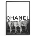 Load image into Gallery viewer, Fashion Plakat | CHANEL Newspaper Bench – Fashion Art Poster Plakaty.dk | Black and white fashion poster of four women sitting on a bench reading newspapers, with the bold text &quot;CHANEL&quot; across the top half of the image.
