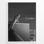 Load image into Gallery viewer, Fashion Plakat | Cartier Panther Over the City: Iconic Elegance in Monochrome Plakaty.dk | Black and white image of a panther perched on a Cartier box overlooking a city skyline at night, with the Cartier logo in the sky.
