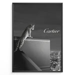 Load image into Gallery viewer, Fashion Plakat | Cartier Panther Over the City: Iconic Elegance in Monochrome Plakaty.dk | Black and white image of a panther perched on a Cartier box overlooking a city skyline at night, with the Cartier logo in the sky.
