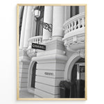 Load image into Gallery viewer, Fashion Plakat | Chanel Boutique Exterior – Monte Carlo, Monaco Plakaty.dk | Black and white photo of the Chanel storefront in Monte Carlo, Monaco, showcasing ornate architecture with columns, balconies, and a hanging sign.
