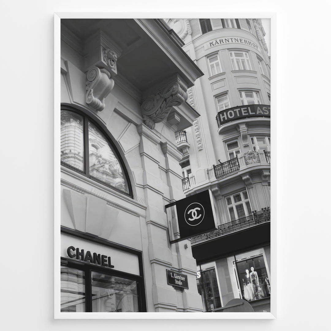 Fashion Plakat | Chanel Boutique Vienna Black & White Architectural Poster Plakaty.dk | Black and white photo of a Chanel store in a European city with ornate architecture and a Chanel flag sign.