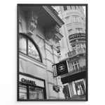 Load image into Gallery viewer, Fashion Plakat | Chanel Boutique Vienna Black &amp; White Architectural Poster Plakaty.dk | Black and white photo of a Chanel store in a European city with ornate architecture and a Chanel flag sign.
