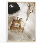 Load image into Gallery viewer, Fashion Plakat | Chanel Gabrielle Perfume Flat Lay with Earrings and Compact – Luxury Beauty Print Plakaty.dk | Flat lay image of Chanel Gabrielle perfume, a black Chanel compact, and gold statement earrings on soft white fabric.
