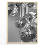 Load image into Gallery viewer, Fashion Plakat | Cluster of Disco Balls in Natural Light Plakaty.dk | Black and white photo of multiple hanging disco balls reflecting natural light near large windows
