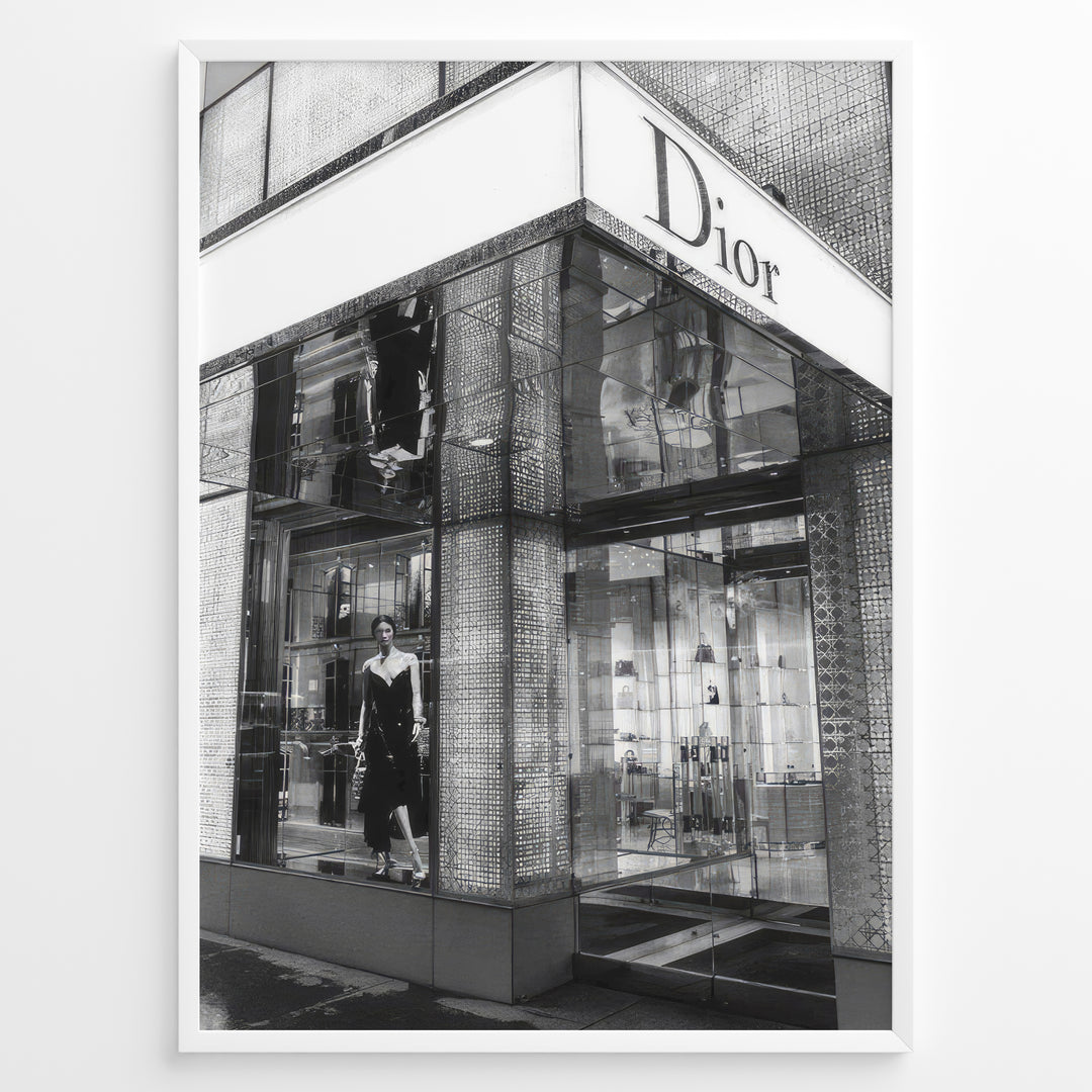 Fashion Plakat | Dior Flagship Storefront – New York City Plakaty.dk | Black and white image of the Dior flagship store in New York City, featuring a glass facade, reflective surfaces, and a mannequin in an elegant outfit.