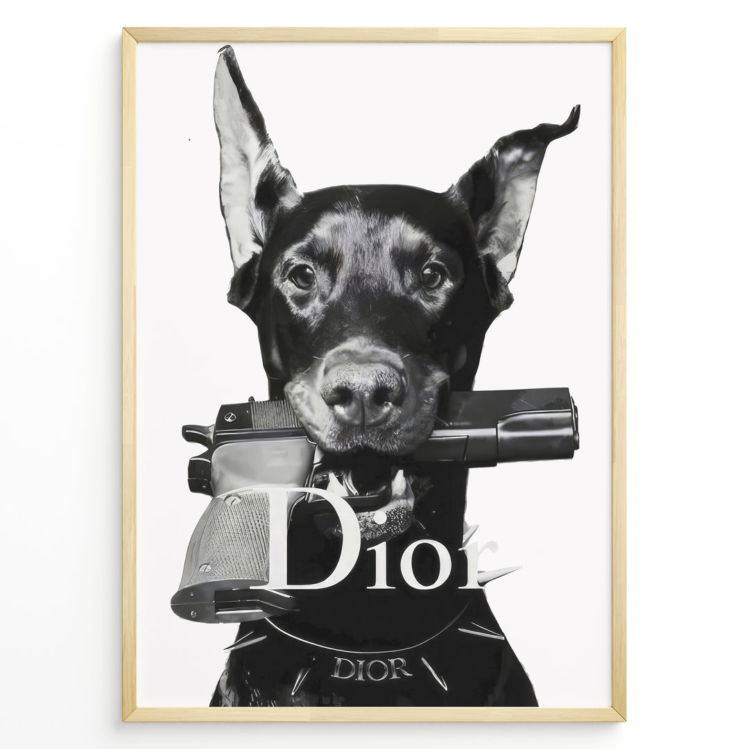 Fashion Plakat | Dior Guard Dog – Bold Fashion Art Print Plakaty.dk | Black and white image of a Doberman dog holding a handgun in its mouth, wearing a spiked collar with the Dior logo, against a plain background.