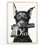 Load image into Gallery viewer, Fashion Plakat | Dior Guard Dog – Bold Fashion Art Print Plakaty.dk | Black and white image of a Doberman dog holding a handgun in its mouth, wearing a spiked collar with the Dior logo, against a plain background.
