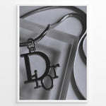 Load image into Gallery viewer, Fashion Plakat | Dior Pendant Necklace – Elegant Black &amp; White Fashion Print Plakaty.dk | Black and white close-up image of a Dior pendant necklace with a metallic chain, showcasing luxury jewelry on a textured background.
