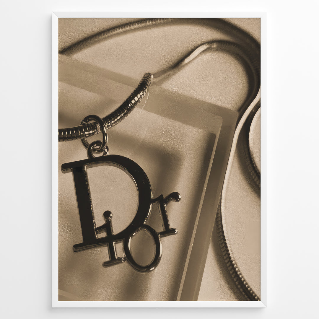 Fashion Plakat | Dior Sepia Necklace Charm – Vintage-Inspired Fashion Wall Art Plakaty.dk | Sepia-toned Dior necklace charm with close-up detail on a textured surface, styled as vintage fashion wall art.