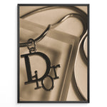 Load image into Gallery viewer, Fashion Plakat | Dior Sepia Necklace Charm – Vintage-Inspired Fashion Wall Art Plakaty.dk | Sepia-toned Dior necklace charm with close-up detail on a textured surface, styled as vintage fashion wall art.
