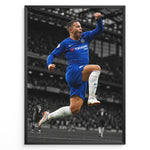 Load image into Gallery viewer, Eden Hazard i Chelsea-trøje under en fejring på fodboldbanen. Motivet har en sort-hvid stadionbaggrund, som fremhæver den blå Chelsea-trøje.
