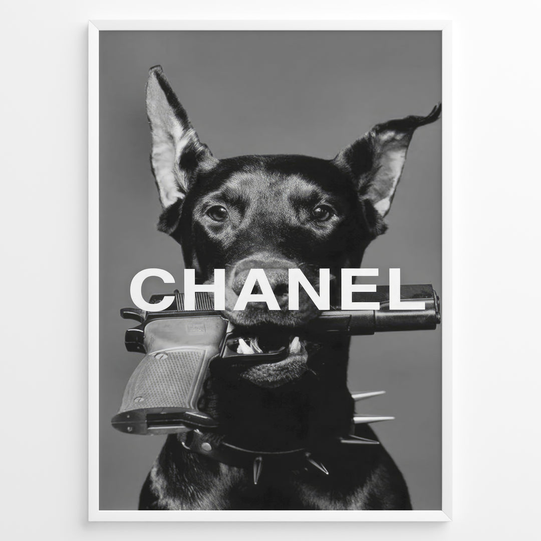 Fashion Plakat | Edgy Chanel-Inspired Art Featuring Dog with Gun Plakaty.dk | Black dog with spiked collar holding a handgun in its mouth, with the word "CHANEL" overlaid in bold white text.