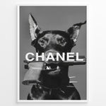 Load image into Gallery viewer, Fashion Plakat | Edgy Chanel-Inspired Art Featuring Dog with Gun Plakaty.dk | Black dog with spiked collar holding a handgun in its mouth, with the word &quot;CHANEL&quot; overlaid in bold white text.
