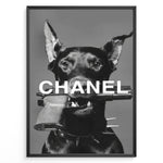 Load image into Gallery viewer, Fashion Plakat | Edgy Chanel-Inspired Art Featuring Dog with Gun Plakaty.dk | Black dog with spiked collar holding a handgun in its mouth, with the word &quot;CHANEL&quot; overlaid in bold white text.
