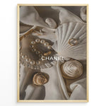 Load image into Gallery viewer, Fashion Plakat | Elegant Chanel-Inspired Flat Lay with Seashells and Jewelry Plakaty.dk | Flat lay of elegant seashells, a pearl bracelet, and gold jewelry on soft ivory fabric with the Chanel logo centered.
