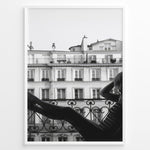 Load image into Gallery viewer, Fashion Plakat | Elegant Woman Relaxing on Parisian Balcony – Black and White Photography Plakaty.dk | Black and white photo of a woman relaxing on a Parisian balcony with classic building architecture in the background
