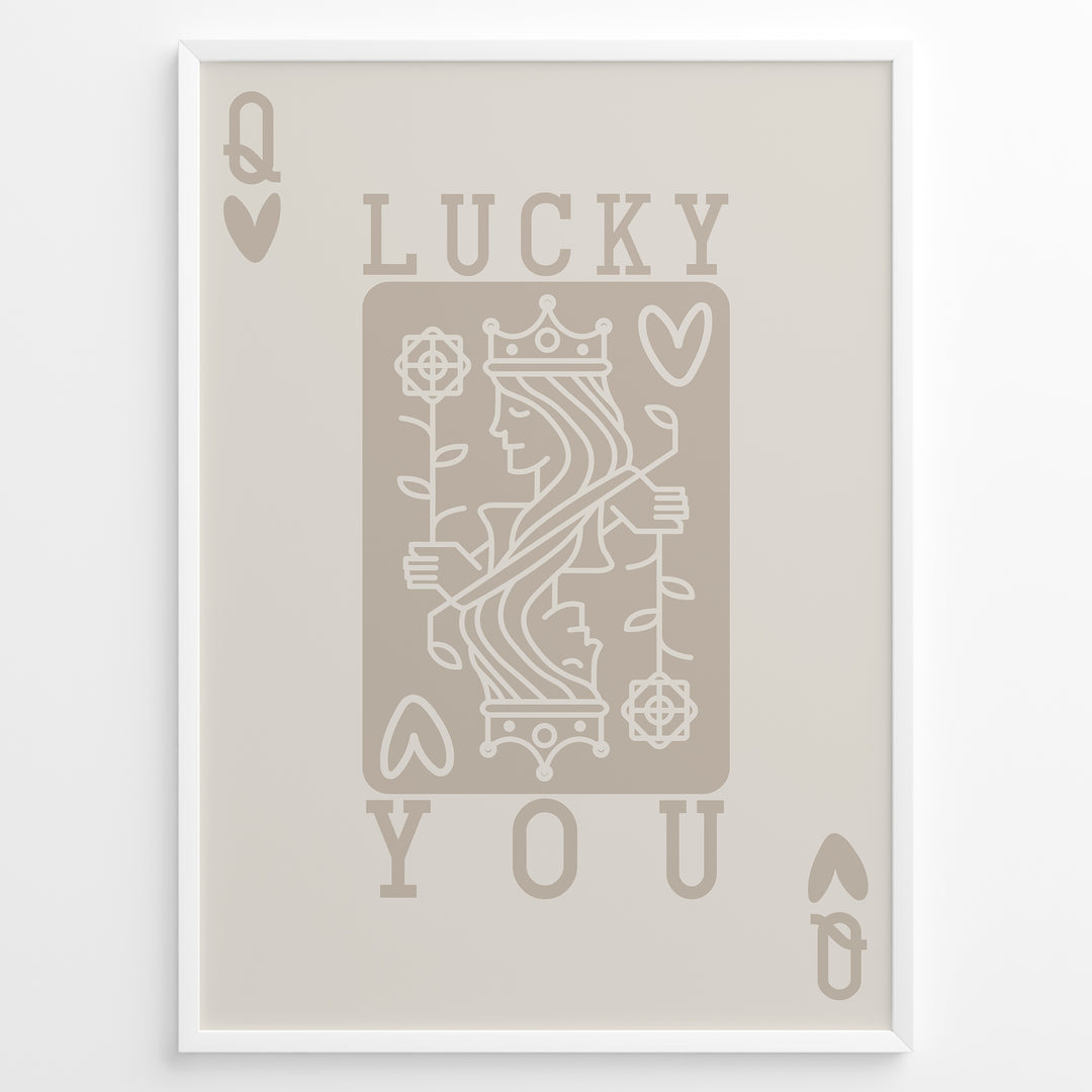 Framed minimalist “Lucky You” poster featuring Queen of Hearts playing card design in beige tones on a neutral background.