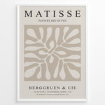 Load image into Gallery viewer, Framed Matisse Papiers Découpés poster with abstract beige cut-out shapes and black typography on a neutral background.
