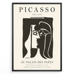 Load image into Gallery viewer, Framed Picasso “The Kiss” poster with two abstract faces in black on a beige background.
