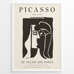 Load image into Gallery viewer, Framed Picasso “The Kiss” poster with two abstract faces in black on a beige background.
