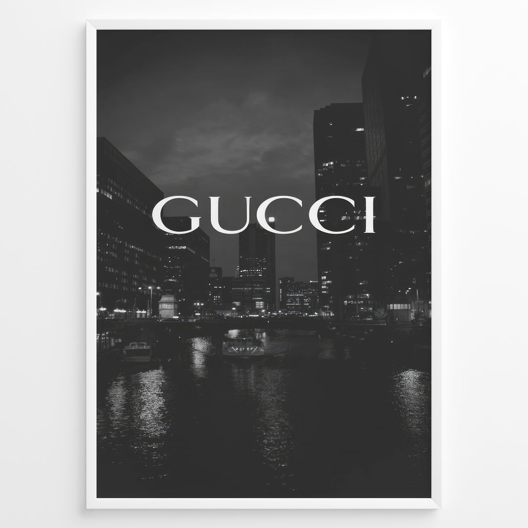 Fashion Plakat | Gucci Cityscape Black & White Fashion Poster Plakaty.dk | Black and white poster with the Gucci logo over a night cityscape featuring tall buildings and water reflections.